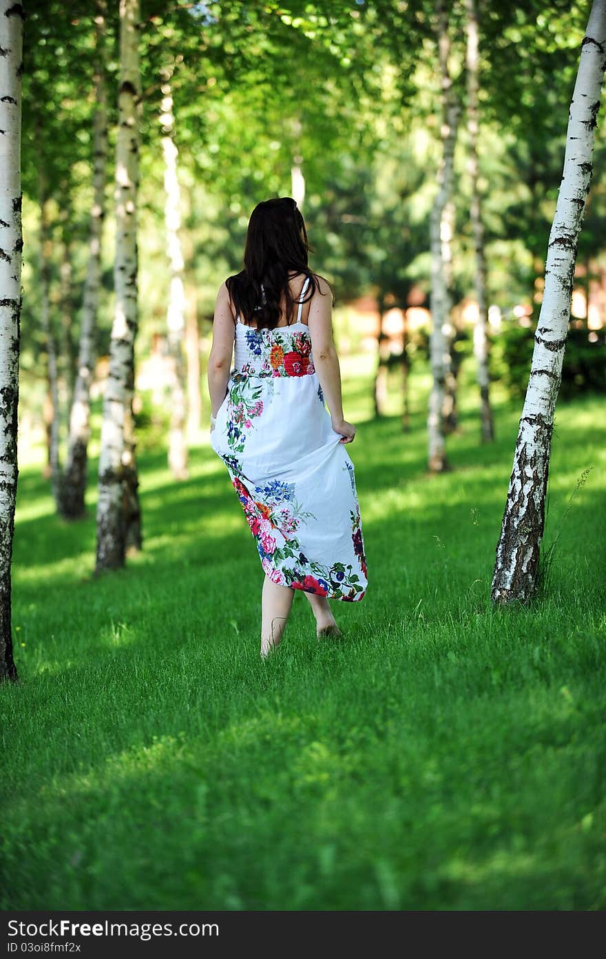 Beautiful woman walking on grass in birch grove . summer's day. Beautiful woman walking on grass in birch grove . summer's day.