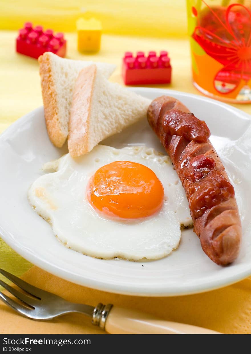 Breakfast of eggs, sausages, toast and juice for kids. Selective focus