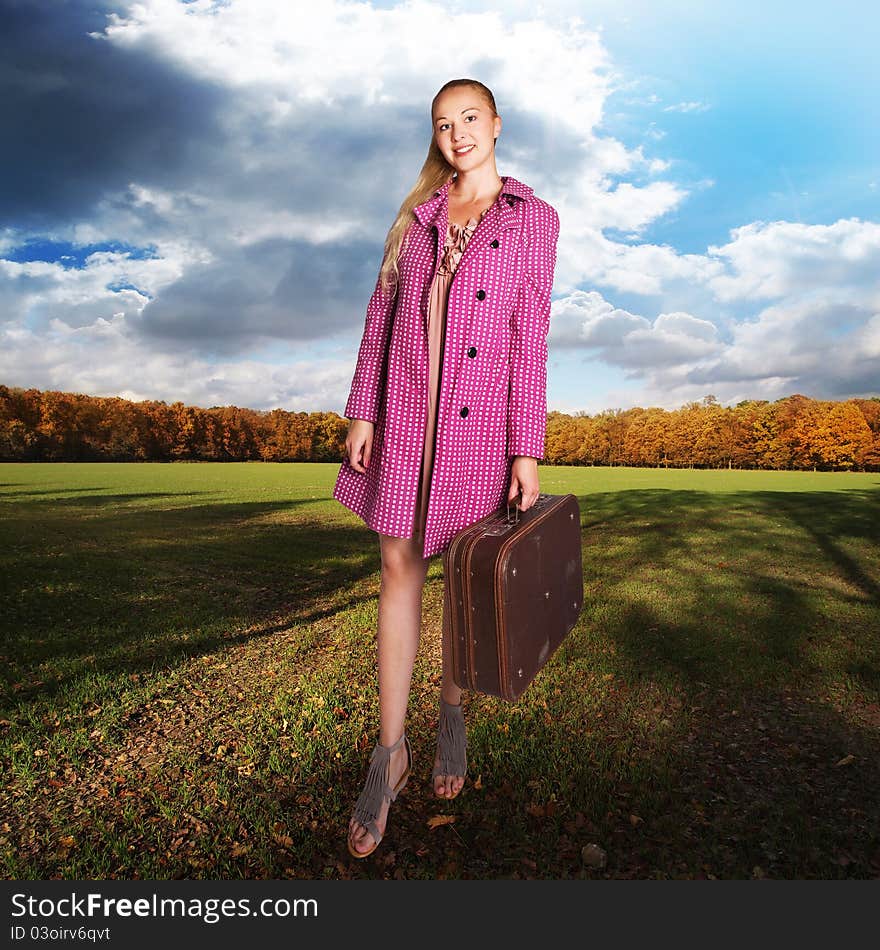 girl with vintage suitcase on field