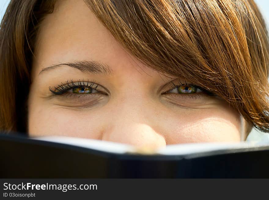 The girl looks out because of the book close up