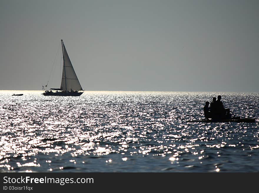 At this fografii depicts a sailboat at sunset.