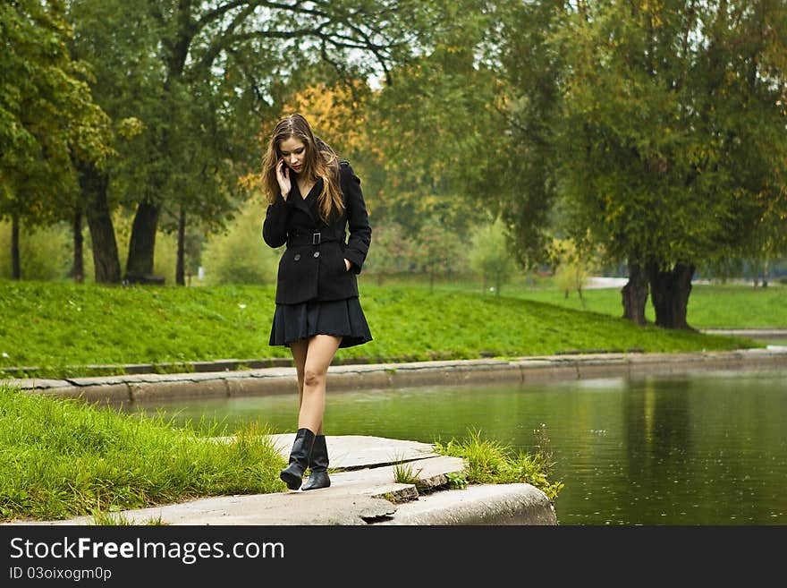 Beautiful girl walks in the park in autumn