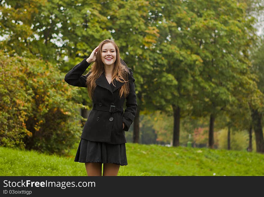 Beautiful girl walks in the park in autumn