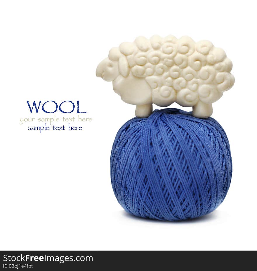 Blue ball of woollen thread on white with lamb figure soap on it