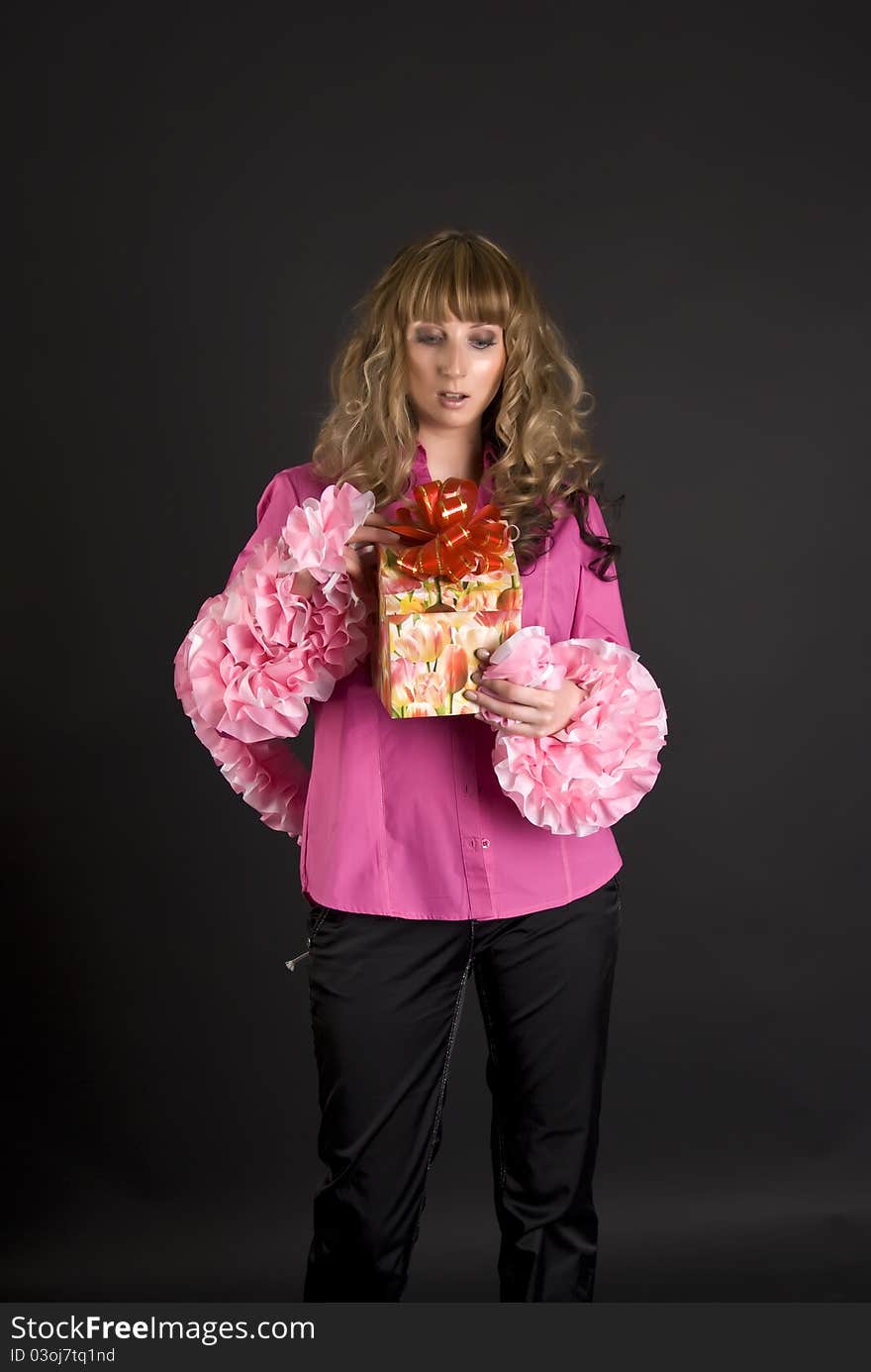 Portrait of the girl of model with a voluminous hair with a gift in hands. Portrait of the girl of model with a voluminous hair with a gift in hands