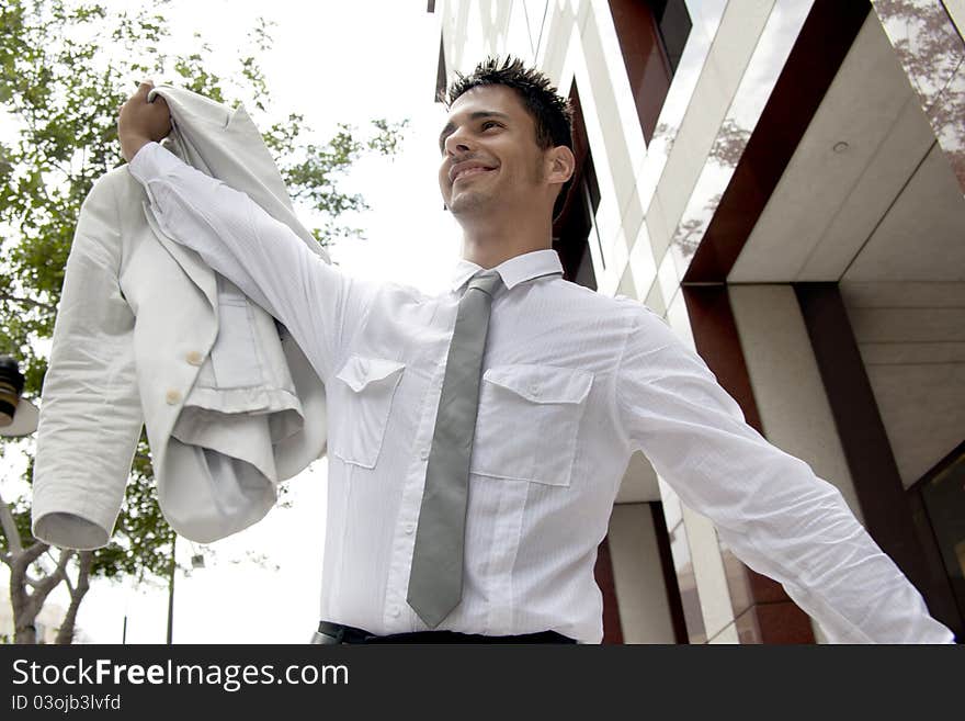 Smiling business man holidng his jucket up high feeling happy. Smiling business man holidng his jucket up high feeling happy