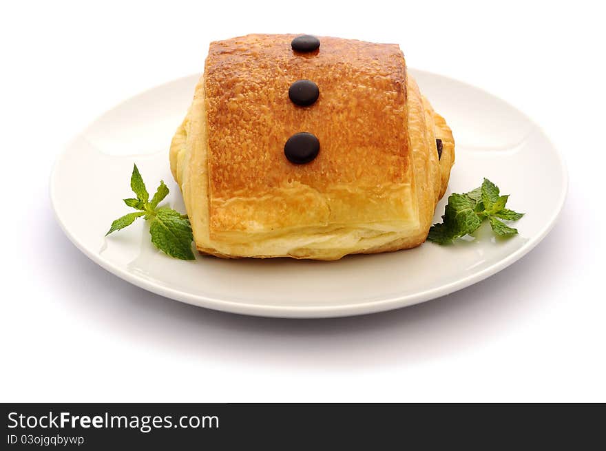 Pain au Chocolat and mint on a white.