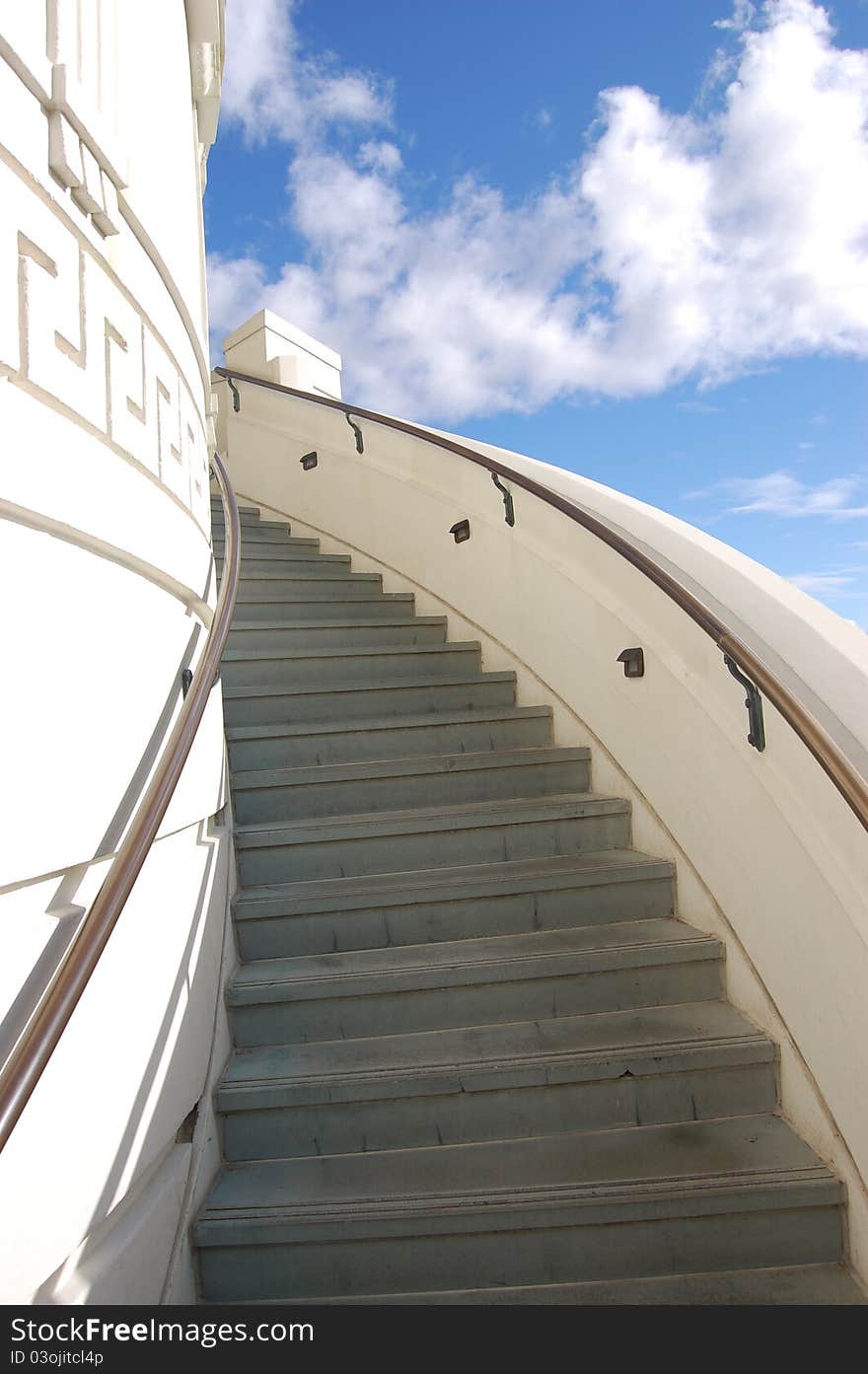 Outdoor spiral staircase with view of blue sky and clouds. Outdoor spiral staircase with view of blue sky and clouds