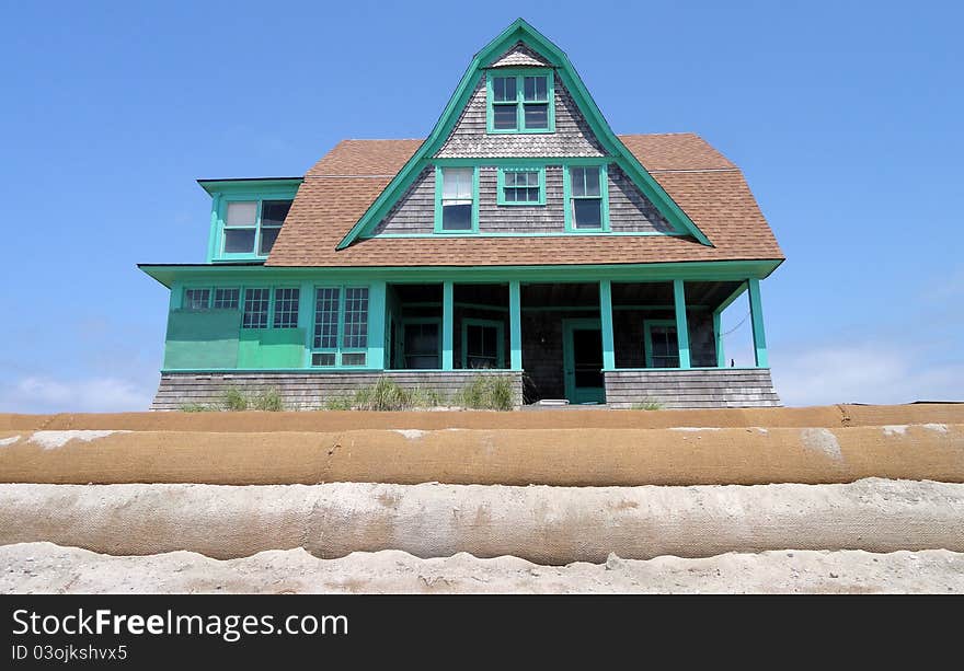 Victorian home on the beach surrounded with sandbags. Victorian home on the beach surrounded with sandbags.