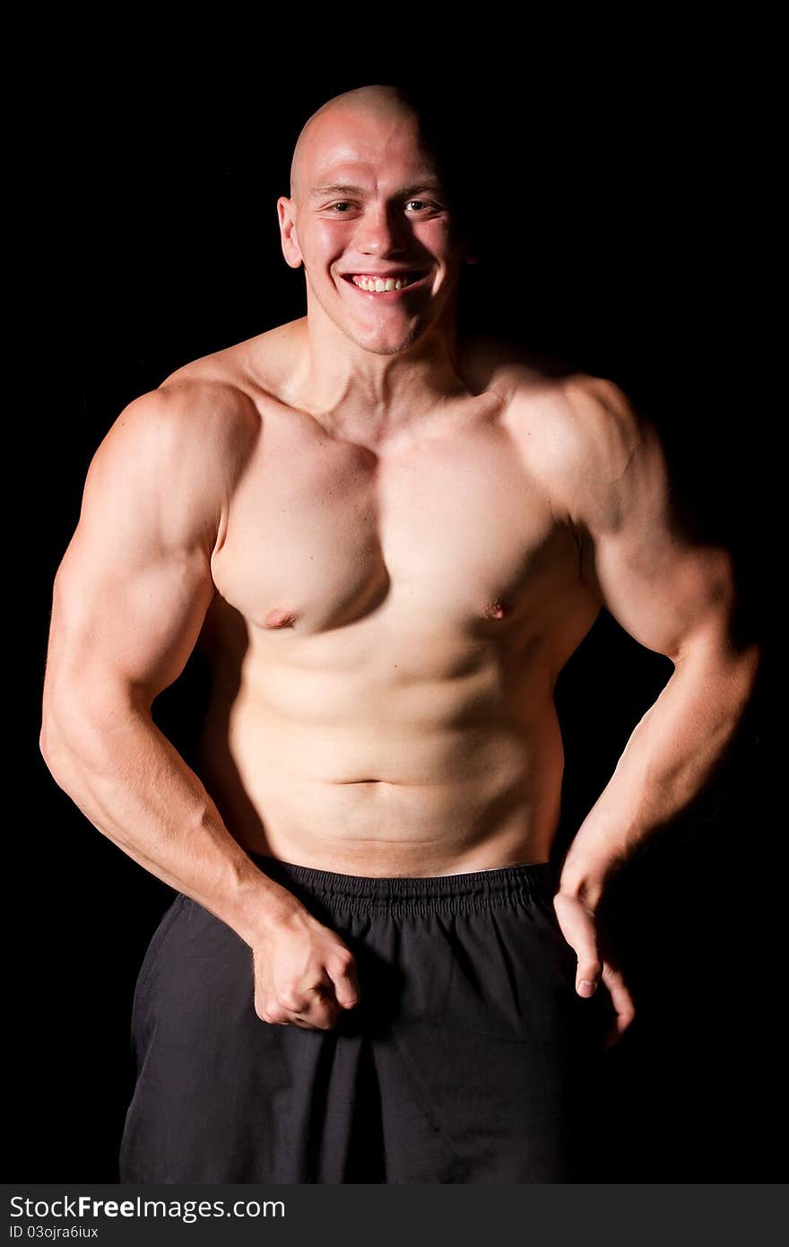 Pumped white guy posing on black background. Pumped white guy posing on black background