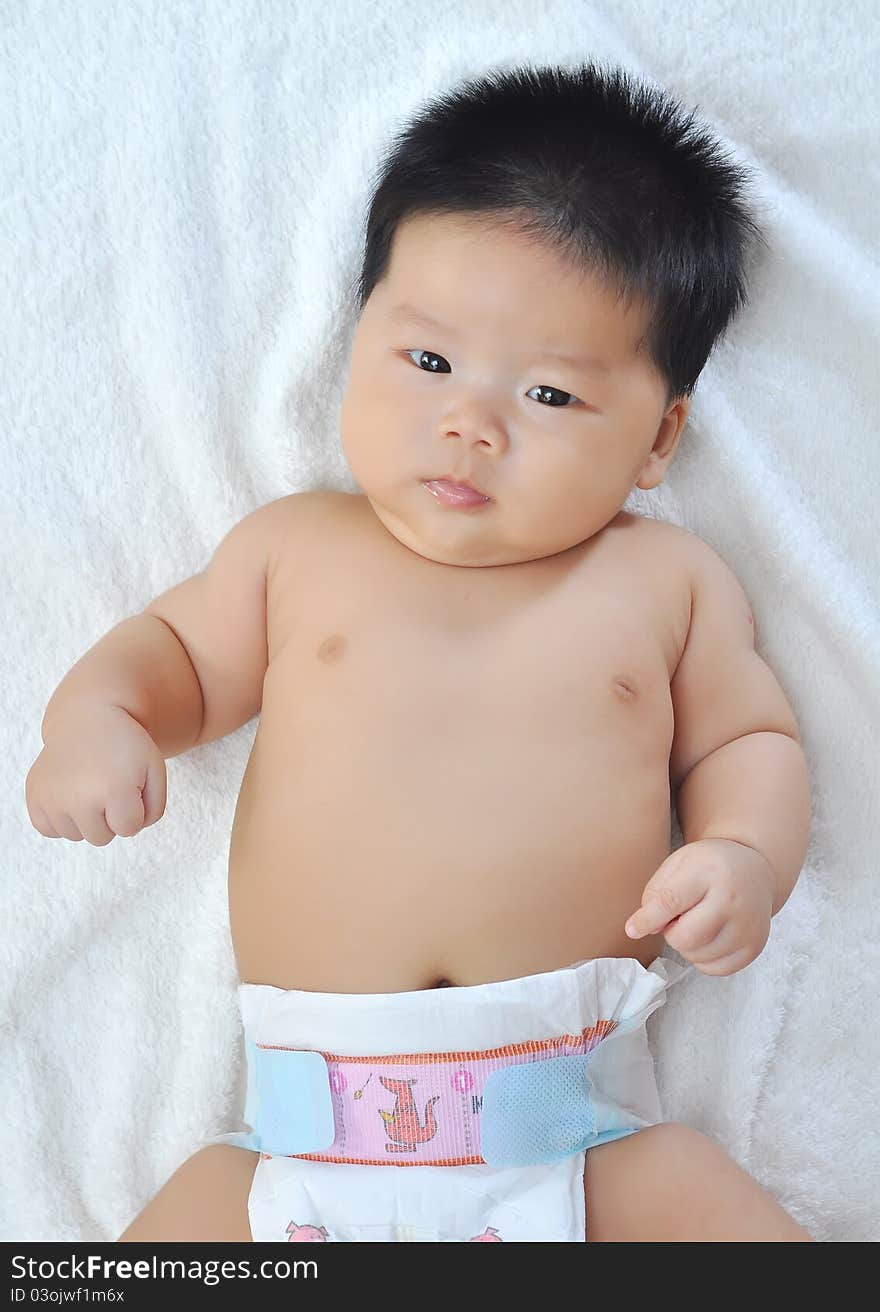 A 3 months chinese Baby girl  lying on the bed