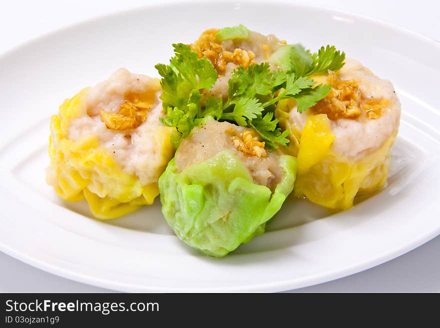 Steamed green and yellow dumplings topped with fried garlic