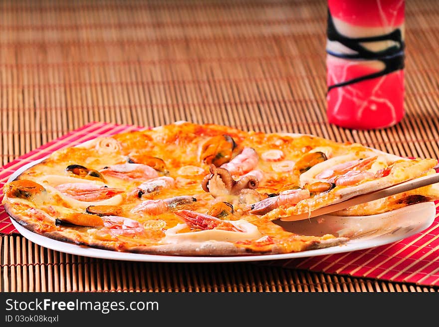 Italian pizza slice on table with candle