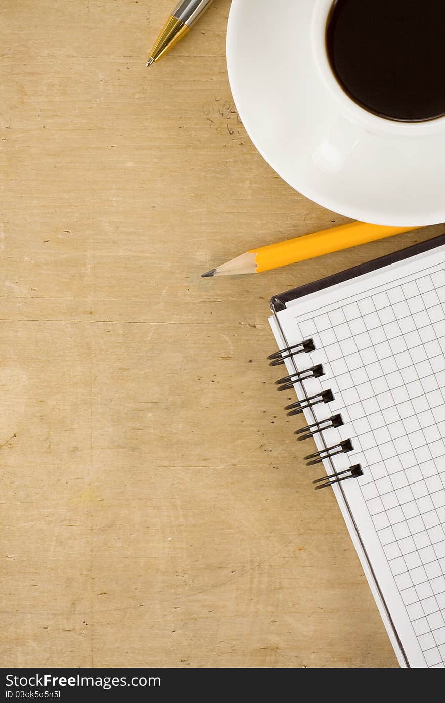 Notebook and coffee on wood