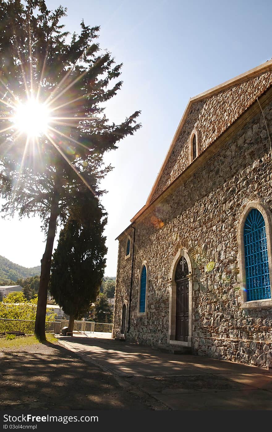 Sun shining through the tree onto a stone built Greek orthodox church in Agros village, Cyprus. Sun shining through the tree onto a stone built Greek orthodox church in Agros village, Cyprus.