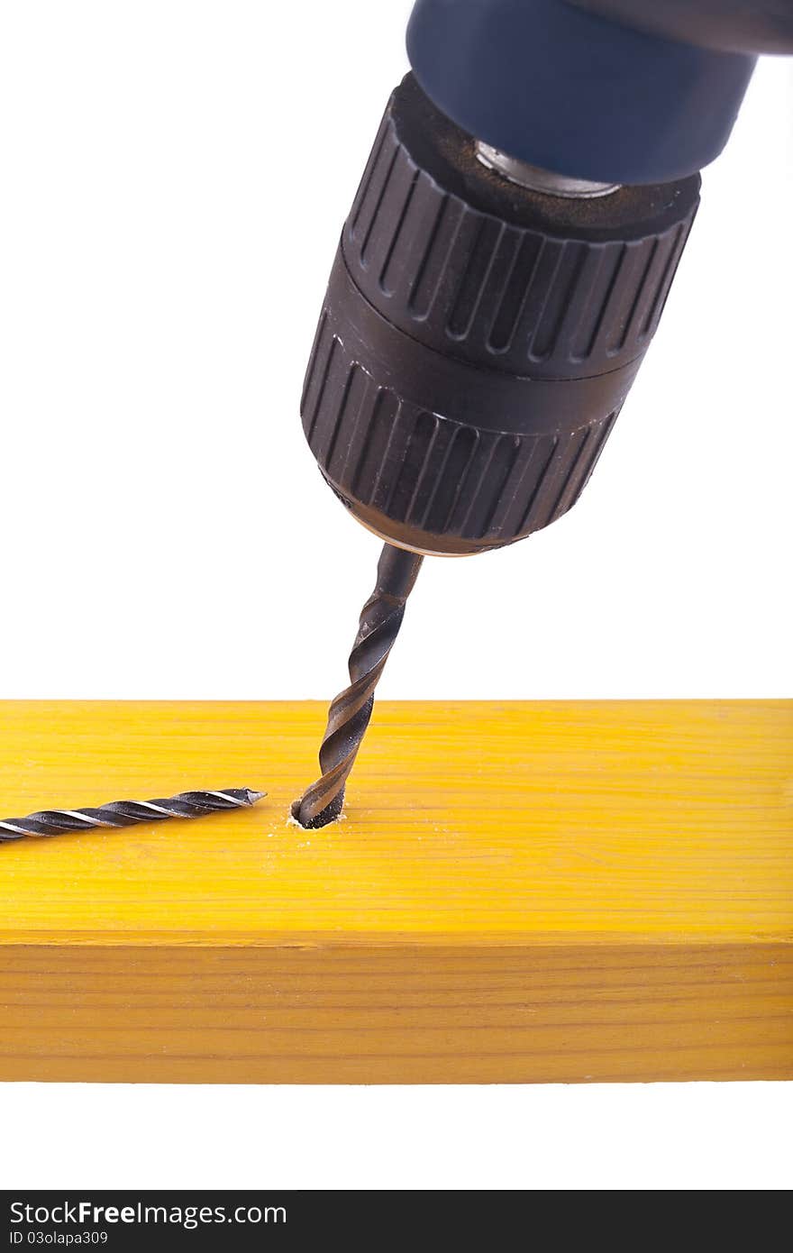 Studio-shot of drilling a hole into wood with a drilling machine, isolated on white.