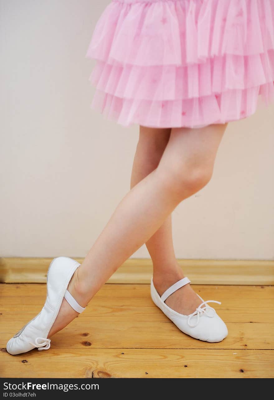 Yound ballerina's legs and feet in pink tutu dress. Yound ballerina's legs and feet in pink tutu dress