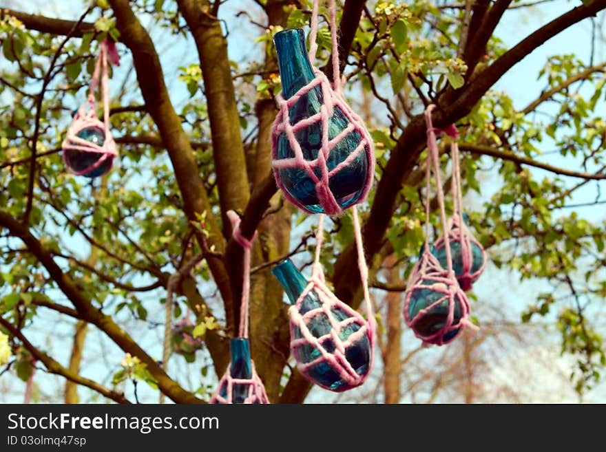 Blue glass vases hanging on the tree. Blue glass vases hanging on the tree