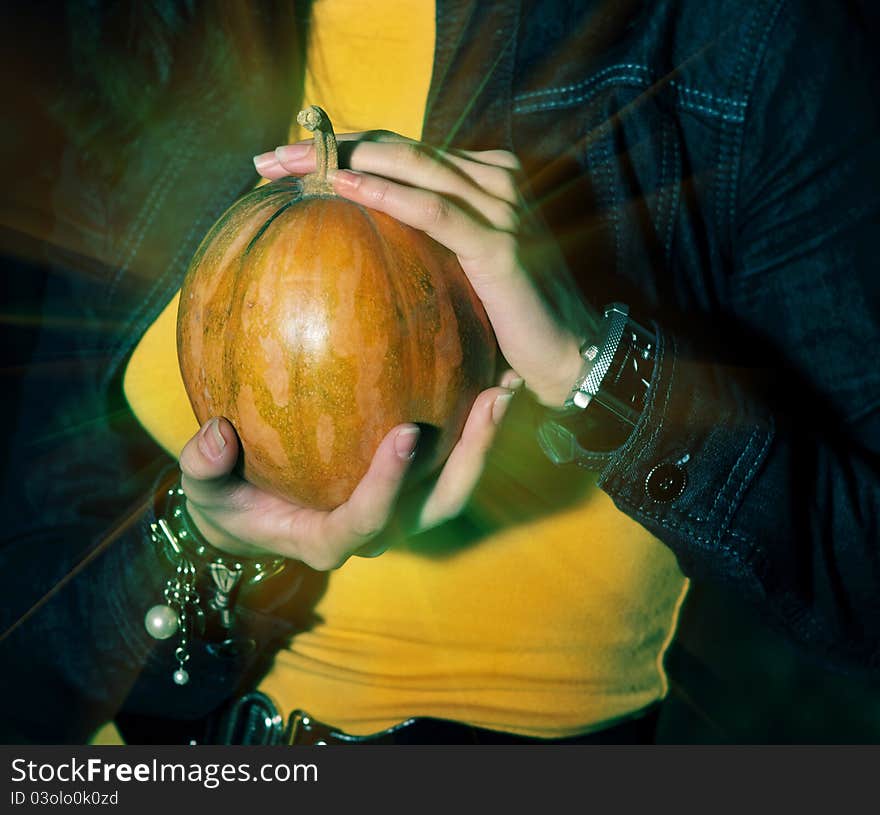 Woman holding halloween shining magic pumpkin