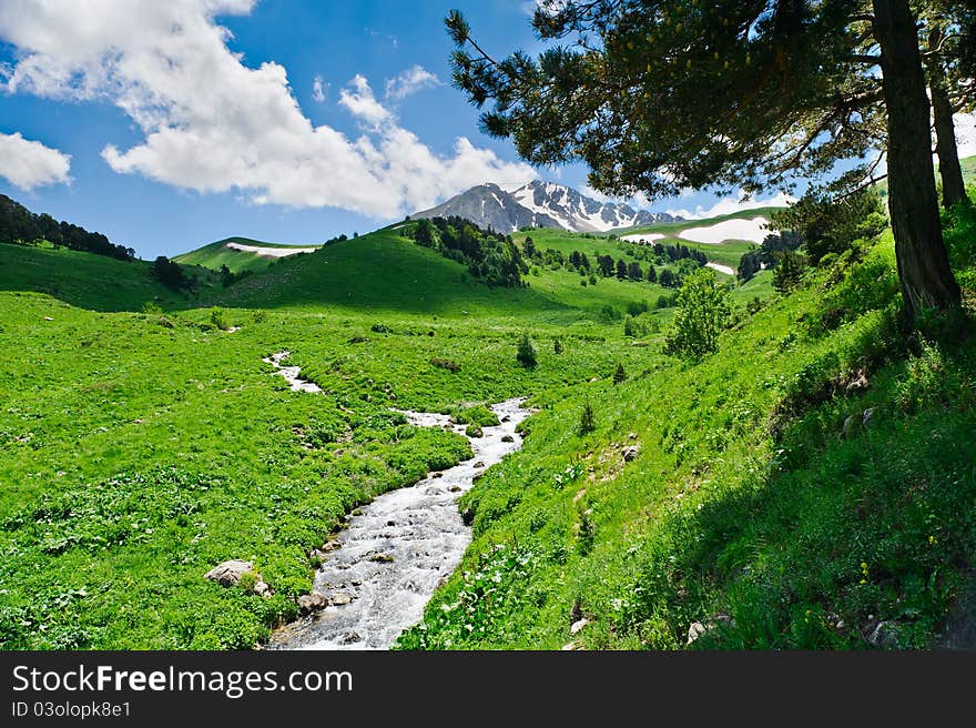 Summer landscape with green grass, mountains and river. Summer landscape with green grass, mountains and river.