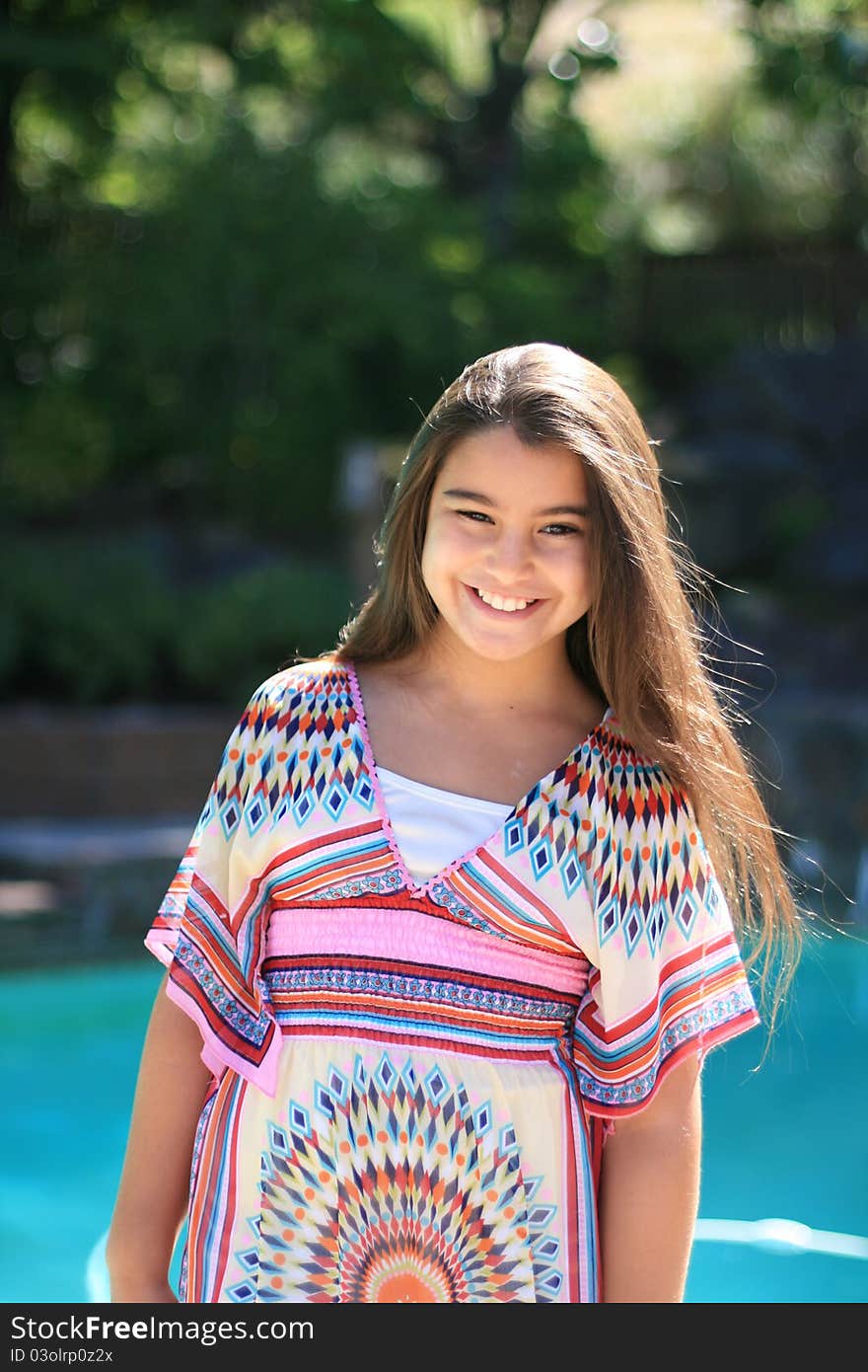 Cute smiling girl outdoors by the pool in summer