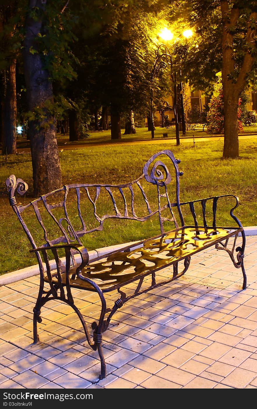 The steel forged bench in the park at night & silence. The steel forged bench in the park at night & silence