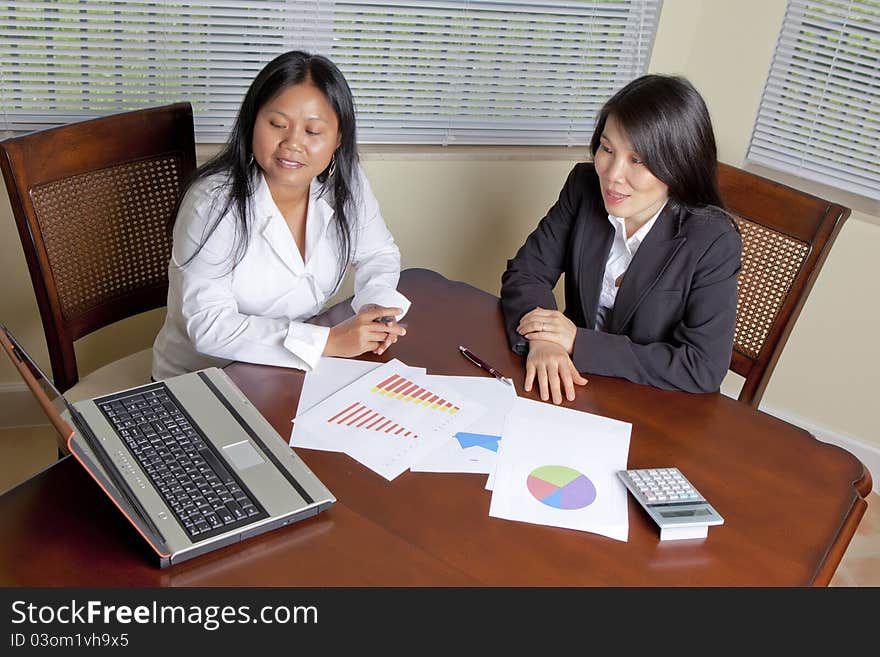 Asian Business women sitting at a desk working.