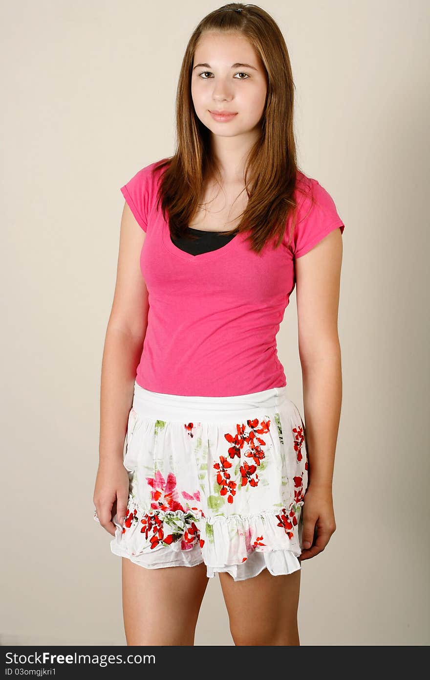 Thirteen year old girl poses wearing a pink shirt with a skirt. Thirteen year old girl poses wearing a pink shirt with a skirt.