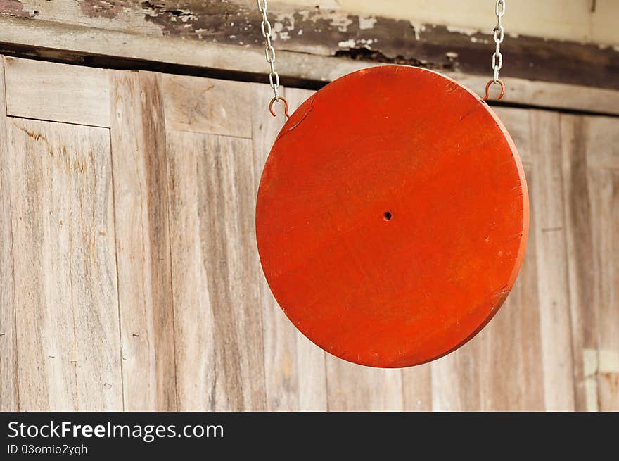 Red wooden signboard hanging in front of the house