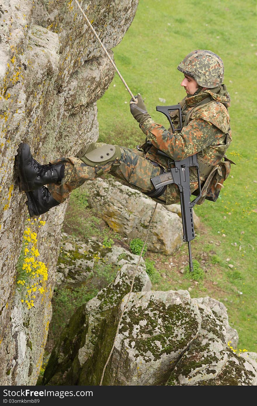 Military man does dangerous rappeling in combative ammunition. Military man does dangerous rappeling in combative ammunition