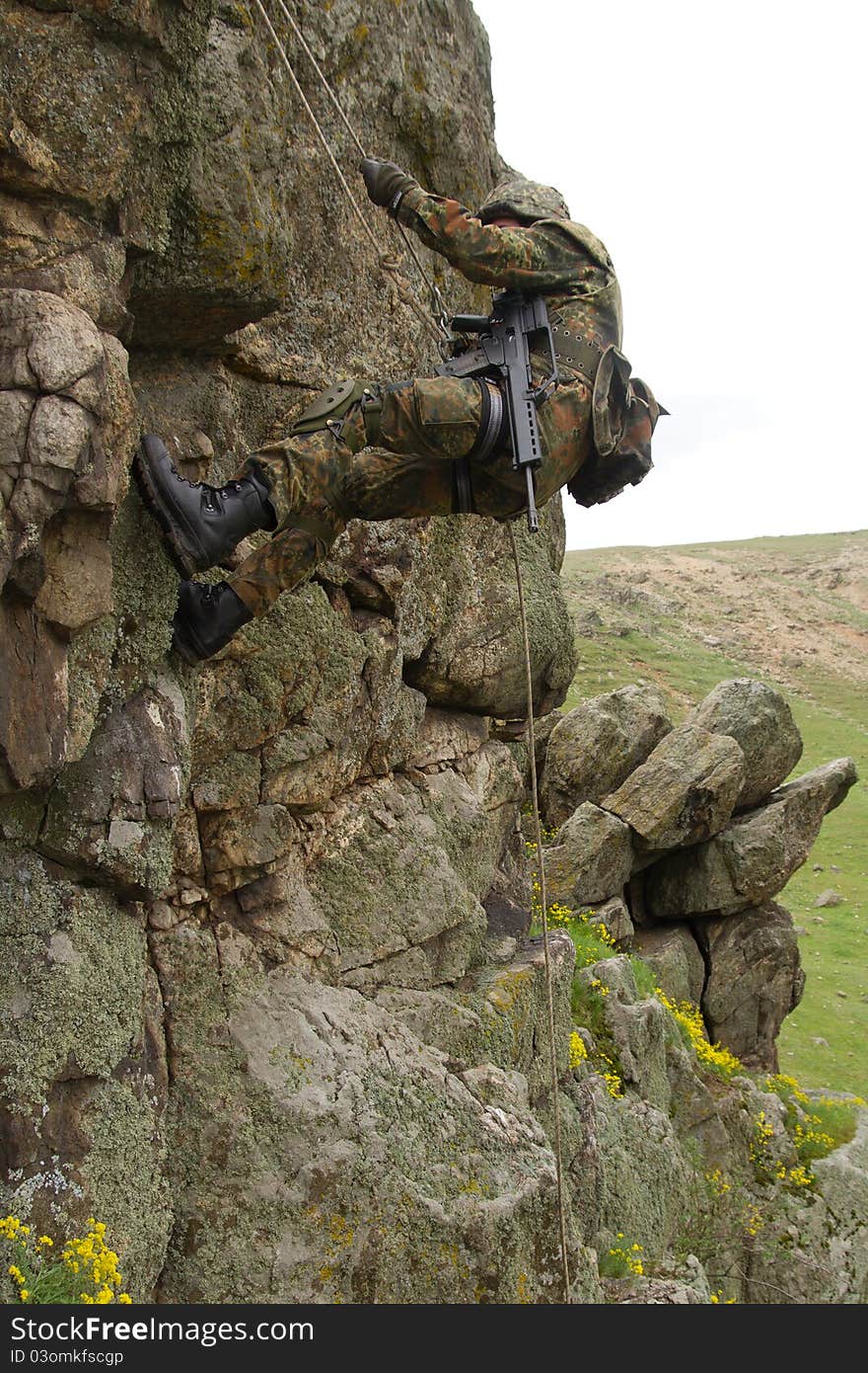 Military man does dangerous rappeling in combative ammunition. Military man does dangerous rappeling in combative ammunition