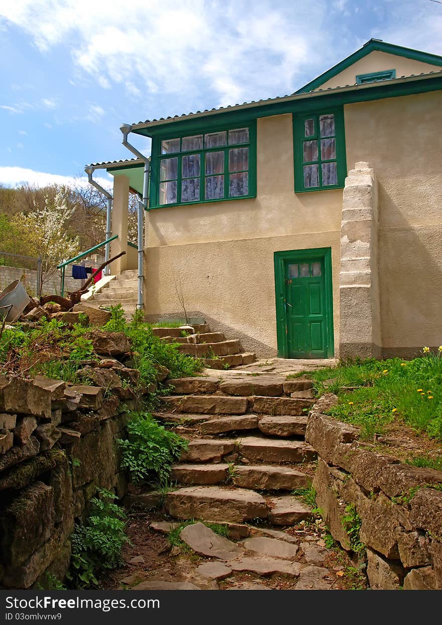 The old house with green windows, door and stony stairs. The old house with green windows, door and stony stairs