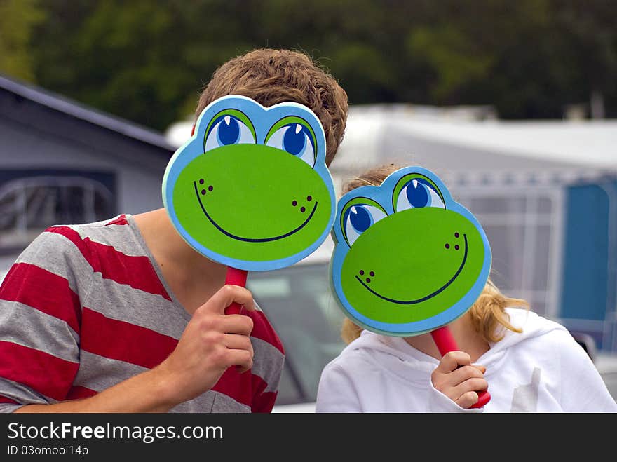 Boy and girl playing with frog masks. Boy and girl playing with frog masks