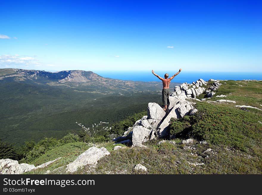 man costs on a rock, having lifted upwards hands