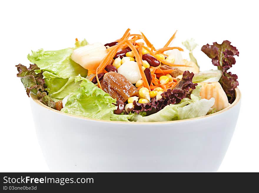 Mixed salad in salad bowl over white