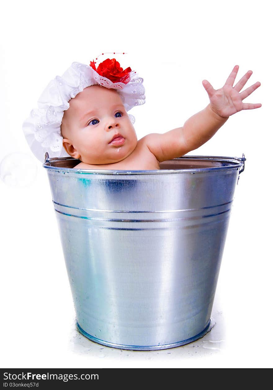 Little baby on a bucket on white background