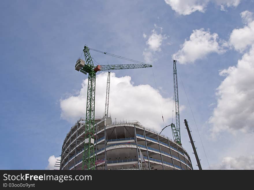 Two Tower Cranes on top of a new construction site lifting steel