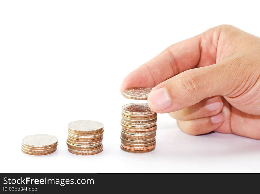 Stack money and a hand in action on white Background isolate and action putting a coin. Stack money and a hand in action on white Background isolate and action putting a coin.