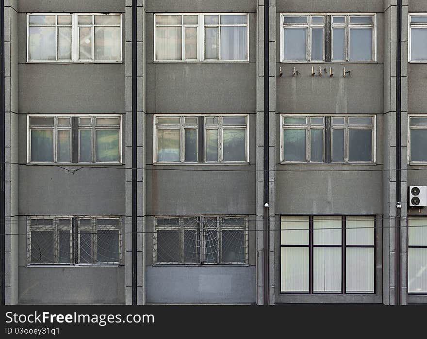 Photo of the grey building wall with nine windows and three halfs. Photo of the grey building wall with nine windows and three halfs