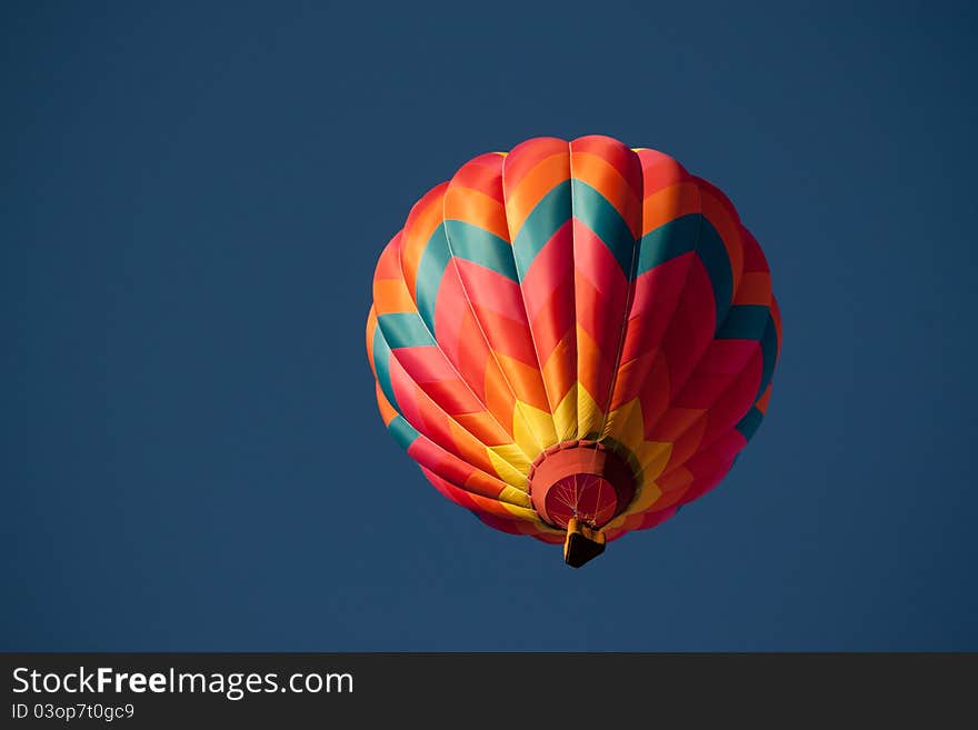 A colorful hot air balloon passes overhead. A colorful hot air balloon passes overhead