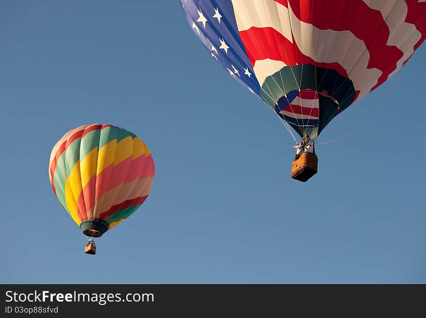 2 colorful hot air balloons flying away. 2 colorful hot air balloons flying away