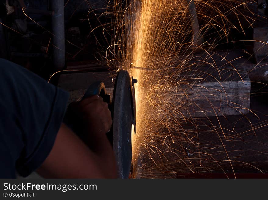 Man cutting steel with a small grinder