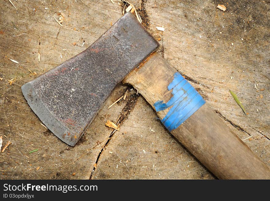 An old ax on a tree stump with woodchips. An old ax on a tree stump with woodchips