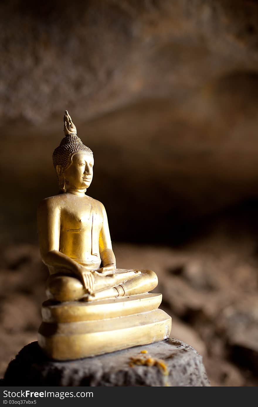 The statue gold Buddha costs in a cave of monks