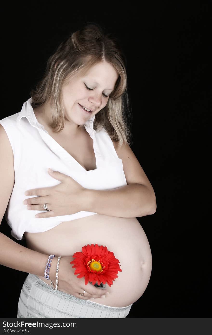 Heavily pregnant blond female against a black background. Heavily pregnant blond female against a black background