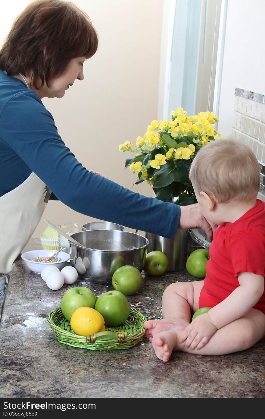 Grandmother and grandson in the kitchen baking cake. Grandmother and grandson in the kitchen baking cake