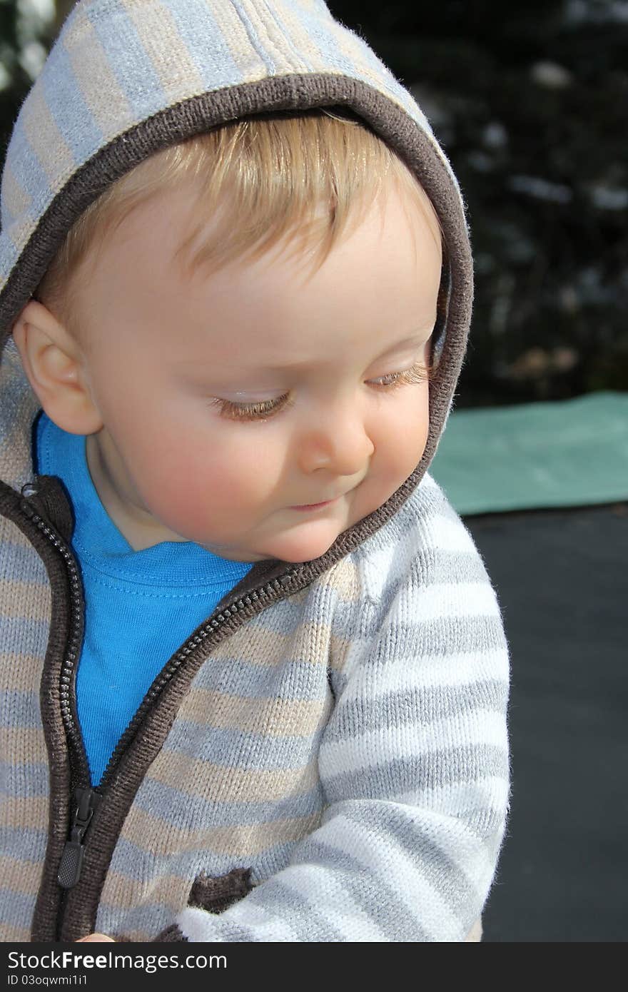 Baby boy playing outside in the garden wearing jersey. Baby boy playing outside in the garden wearing jersey