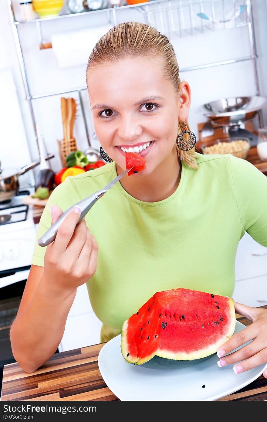 Lovely woman eating watermelon in the kitchen-diet concept. Lovely woman eating watermelon in the kitchen-diet concept