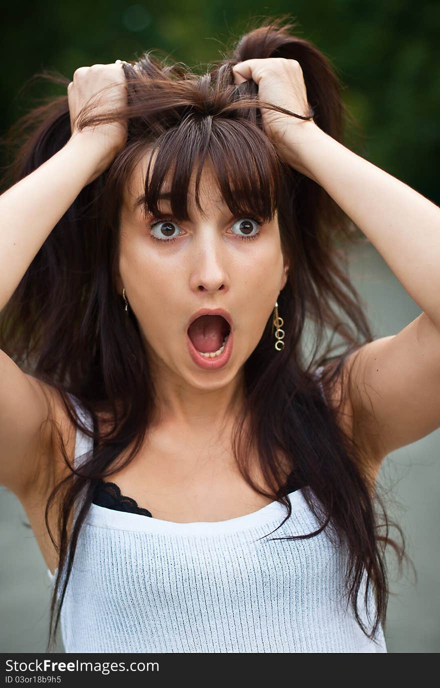 Surprised young woman tearing her hair. Surprised young woman tearing her hair