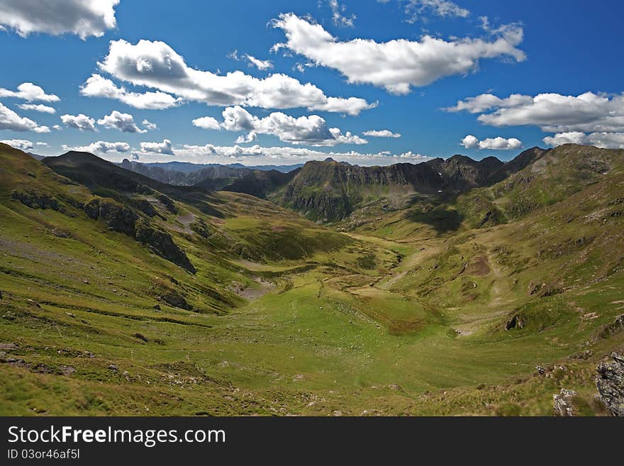 Green Valley with cloudy sky. Panorama by the top of a Valley